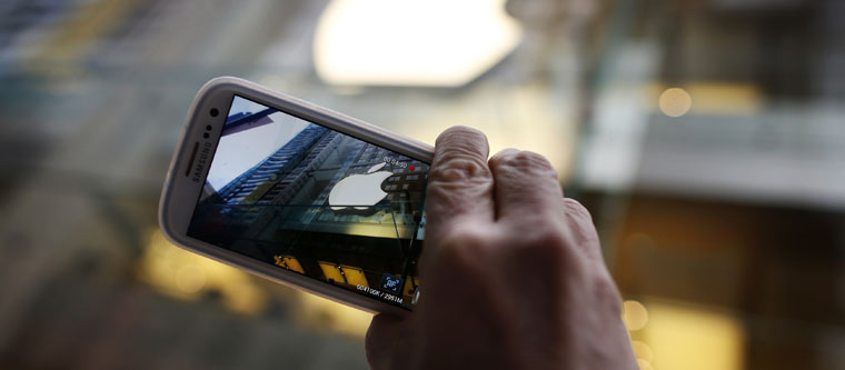 Passerby photographs Apple store logo with his Samsung Galaxy phone in central Sydney