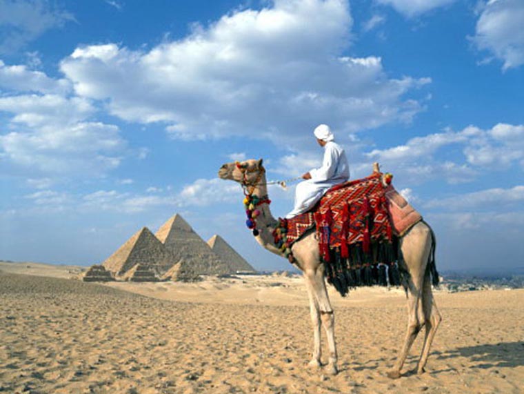 Egypt, Cairo, Man on camel in front of the pyramids of Giza