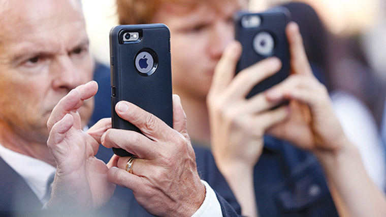 People use iPhones at the film premiere of 