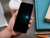 Man,Holding,A,New,Mobile,Phone,With,Esim,,Close,Up Как работает eSIM? Разбираемся, чем цифровая симка лучше или хуже старого доброго пластика